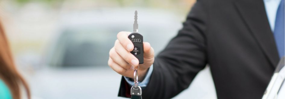 Salesman holding a key featured in a blog about Audi lease deals